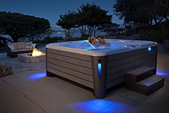 a couple enjoys an evening soak in a grandee nxt hot tub